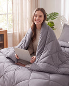 Femme enveloppée dans la couette 2-en-1 grise